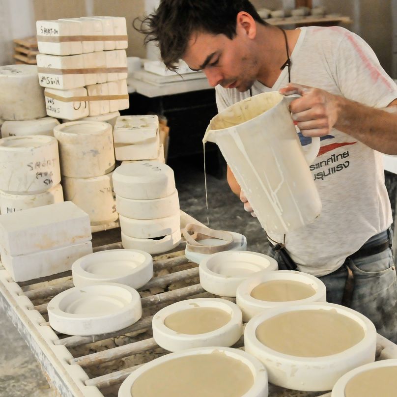 A caster pours the slip into plaster molds